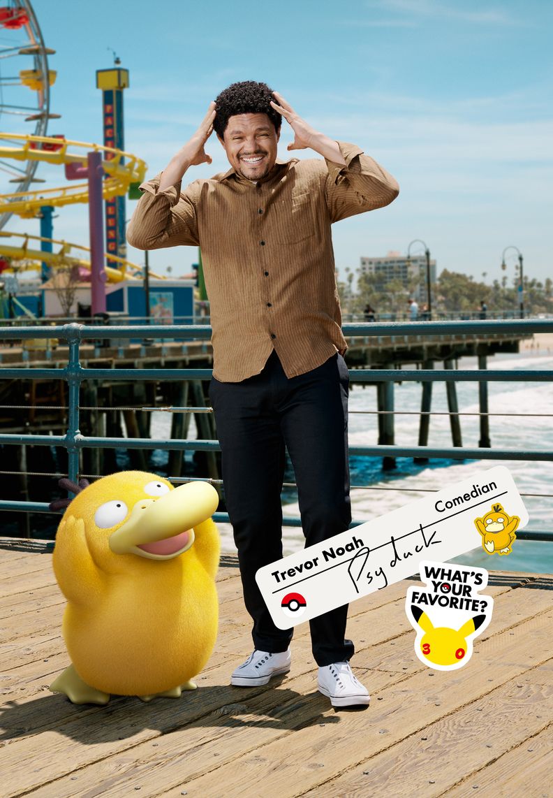 Comedian Trevor Noah stands on a pier next to Psyduck. Trevor’s hands are held near his temples as he recreates his Pokémon’s iconic pose.
