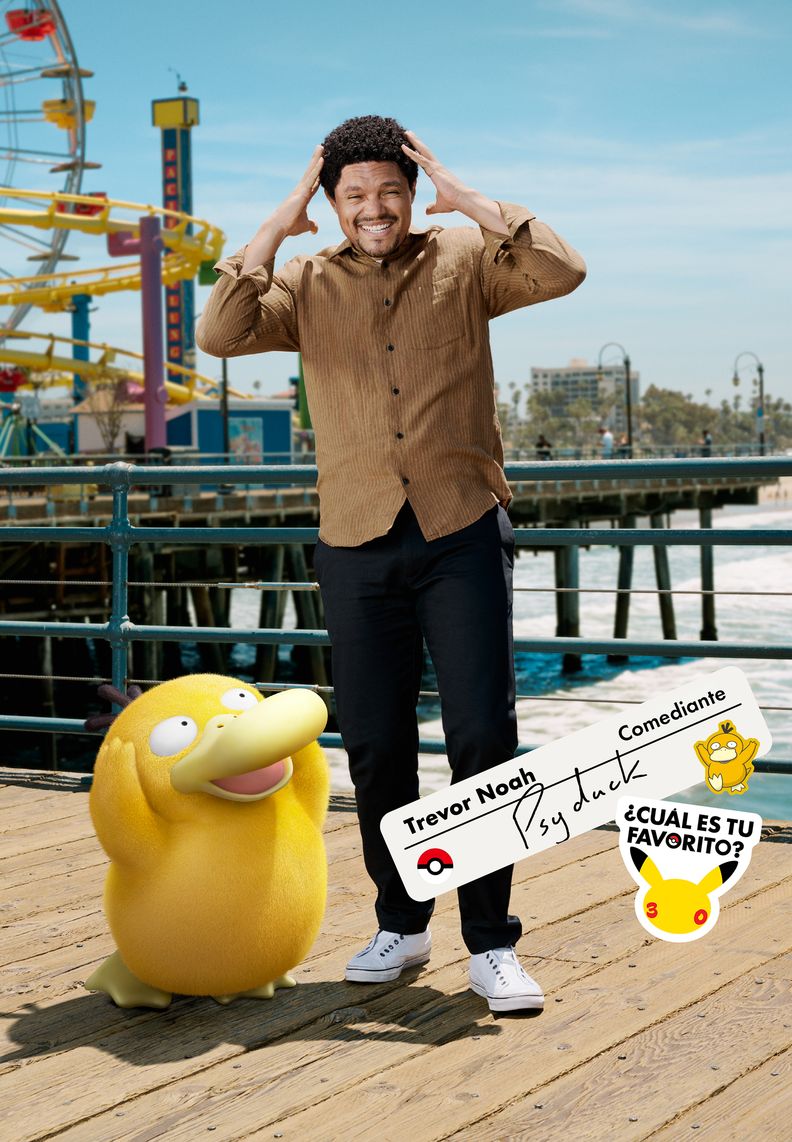 El comediante Trevor Noah parado en un muelle junto a Psyduck. Trevor tiene las manos a los costados de la cabeza recreando la icónica pose del Pokémon.
