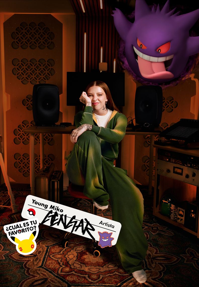 La artista Young Miko está sentada en un estudio. Sobre ella, Gengar está sacando la lengua.