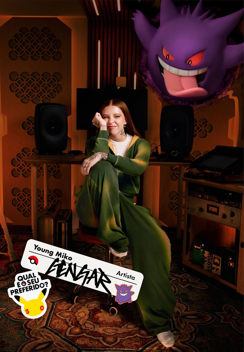 A artista Young Miko aparece sentada em um estúdio. Acima, Gengar mostra a sua língua.